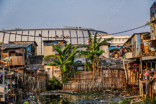 view of poor residential houses on the outskirts of the city with buildings in the background with the sky as copy space, slum dwellings on the banks of the river. photo