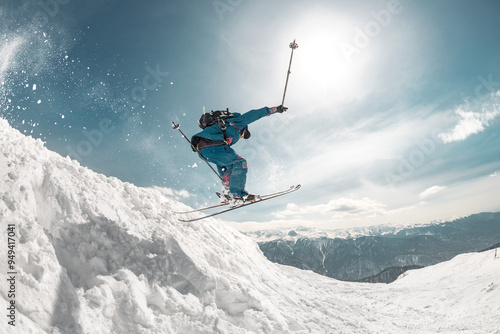 Fast and professional skier jumps at big speed from snowdrift high in mountains photo