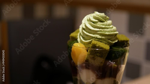 close up view to beautiful parfait sweet dessert in japanese style full with ice cream mochi green tea yelly and topped with green tea cream in japanese minimal cafe photo