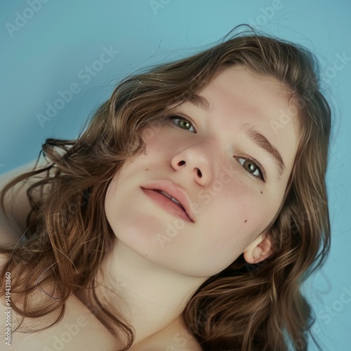 Close-up portrait of a young woman with brown hair and freckles looking directly at the camera.