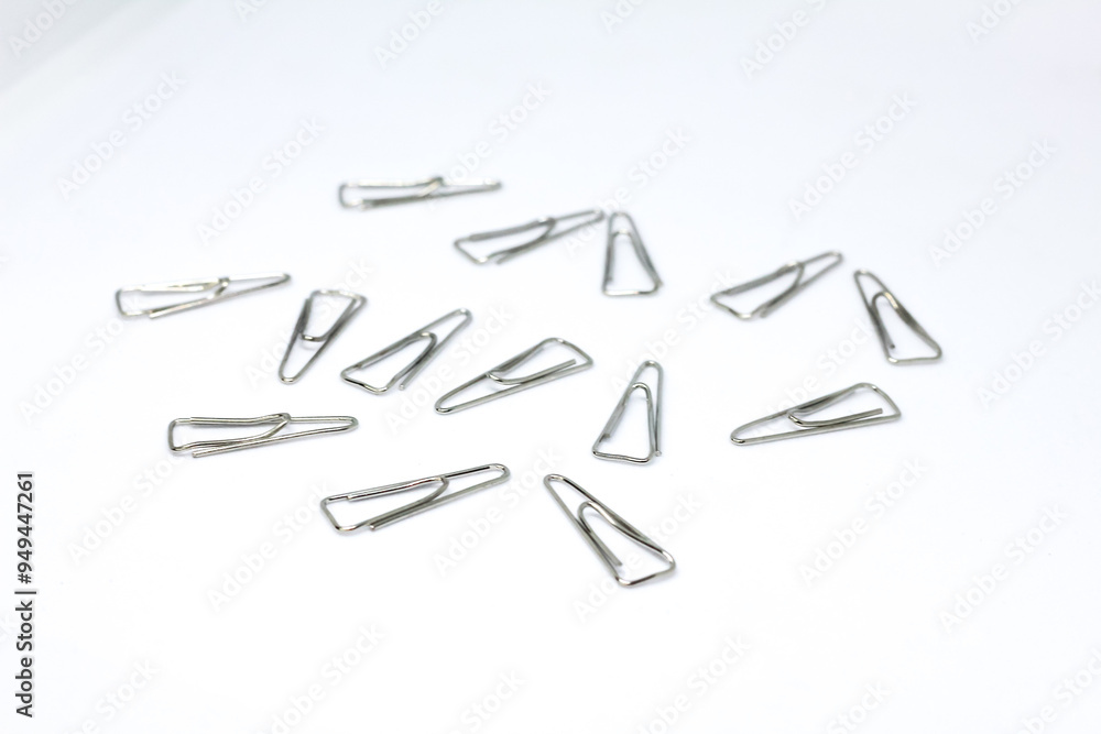 iron paper clip isolated on white background. This clip is often used to clamp a stack of paper or documents. iron paper clip isolated on white background. This clip is often used to clamp a stack of paper or documents.