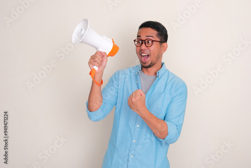 A man looking beside him showing excited expression while holding megaphone photo