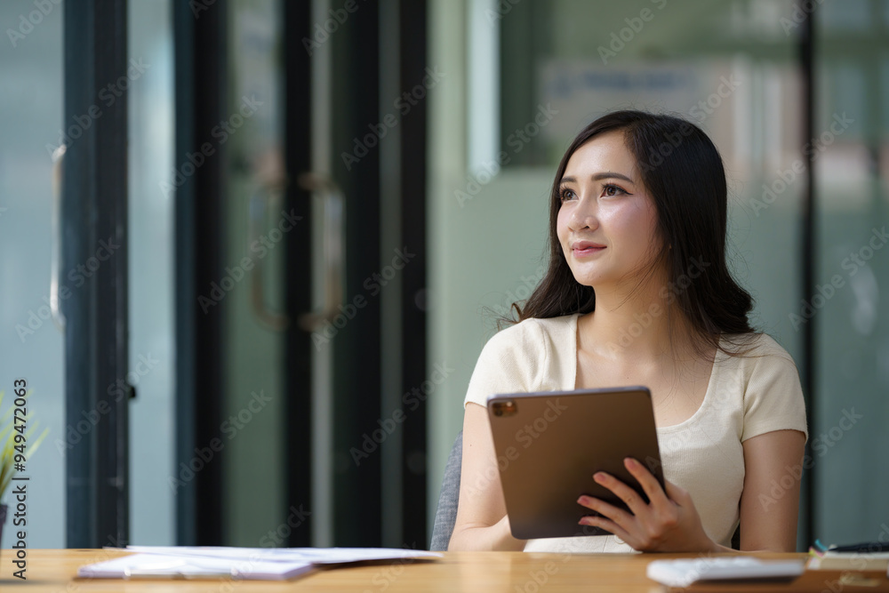 Asian female using a digital tablet at the office. Asian female using a digital tablet at the office.