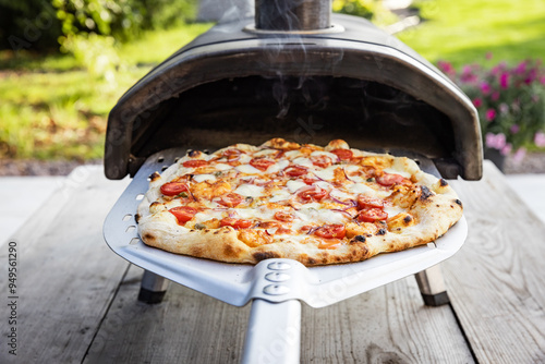 Obraz na płótnie Homemade Pizza. Delicious fresh pizza out of home portable pellets oven. Outdoor pizza party. w salonie