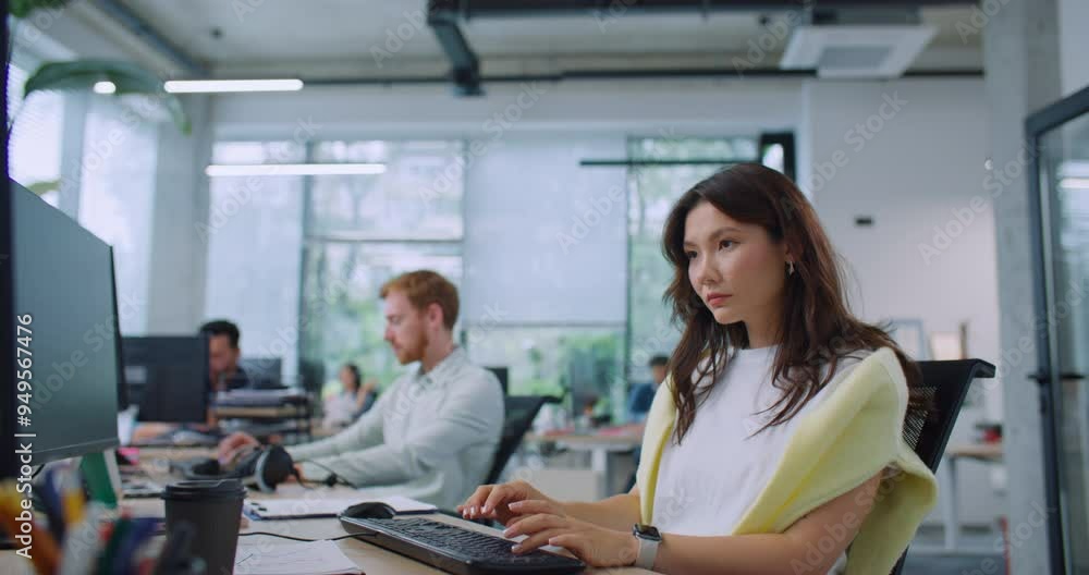 Camera focus on busy woman looking directly at screen and typing text on keyboard in modern office. Hardworking man sitting at desk next to female and observing woman's actions. Working process. Camera focus on busy woman looking directly at screen and typing text on keyboard in modern office. Hardworking man sitting at desk next to female and observing woman's actions. Working process.