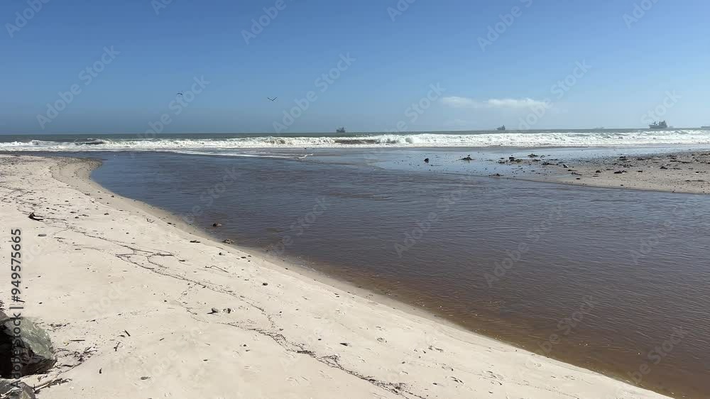 Open river mouth lagoon beach crashing waves and ships out at sea Open river mouth lagoon beach crashing waves and ships out at sea