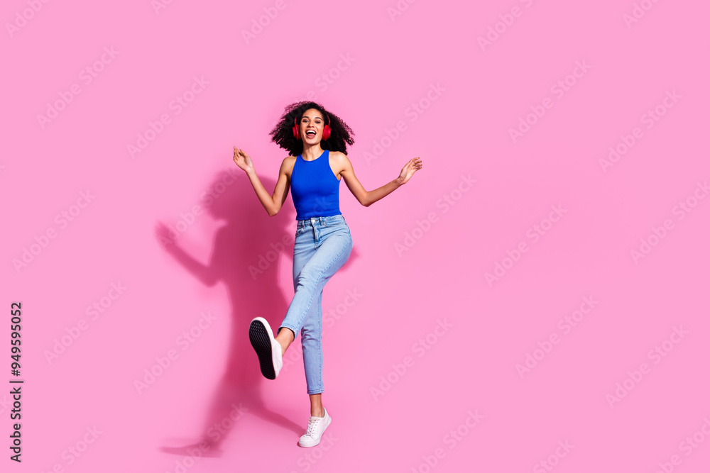 Full body photo of attractive young woman headphones dancing good mood dressed stylish blue clothes isolated on pink color background Full body photo of attractive young woman headphones dancing good mood dressed stylish blue clothes isolated on pink color background
