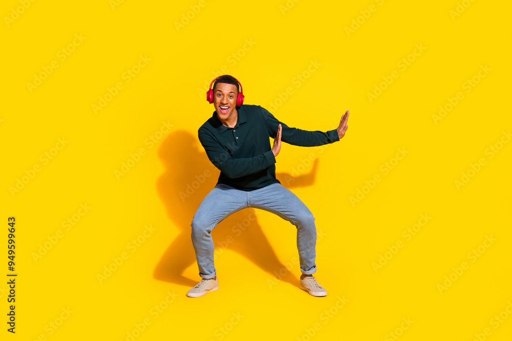 Full body photo of nice young male earphones dance push empty space wear trendy green outfit isolated on yellow color background Full body photo of nice young male earphones dance push empty space wear trendy green outfit isolated on yellow color background