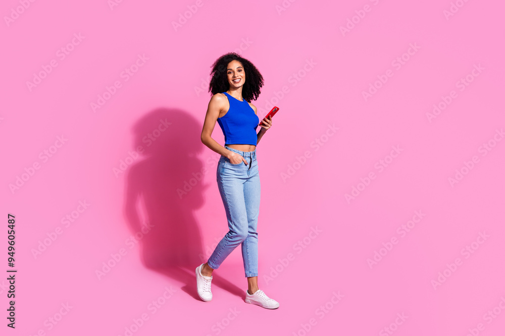 Photo of walking girl hold cell smart device smiling isolated pastel color background Photo of walking girl hold cell smart device smiling isolated pastel color background