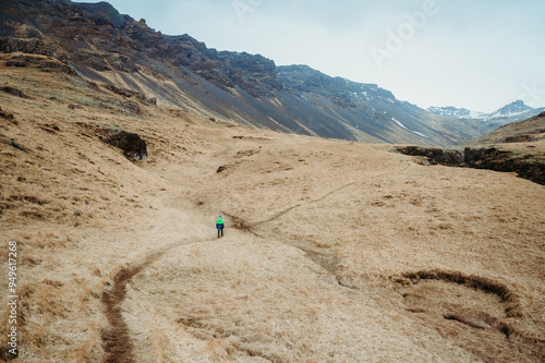 Boy hiking through rugged landscape at Midskalagil Canyon, Iceland. photo