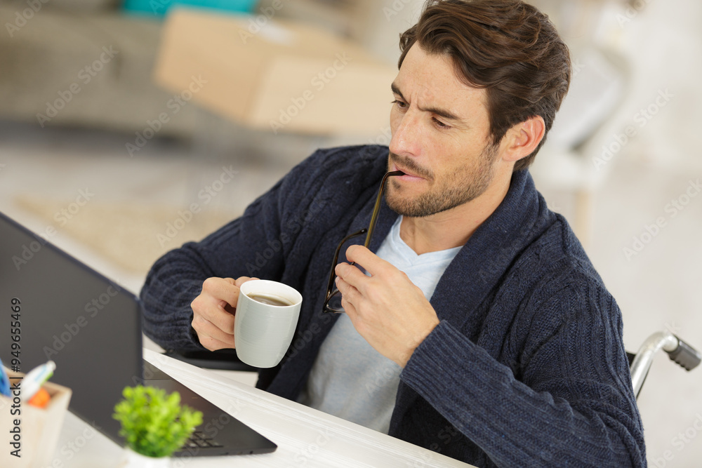 disabled young man with cup of coffee studying disabled young man with cup of coffee studying