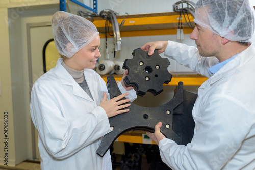 consumption factory workers holding machine part photo