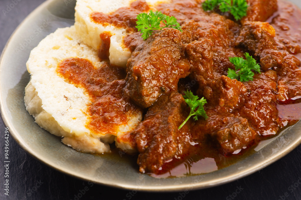 Beef goulash and dumplings (knedliky) on table Beef goulash and dumplings (knedliky) on table