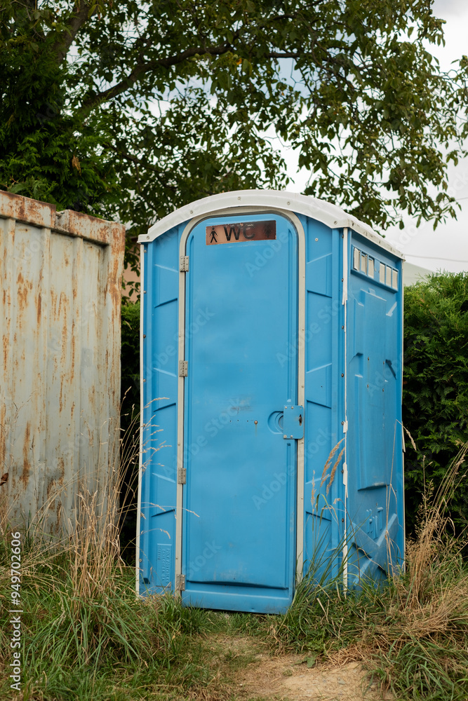Blue plastic portable toilet outdoors. Blue plastic portable toilet outdoors.