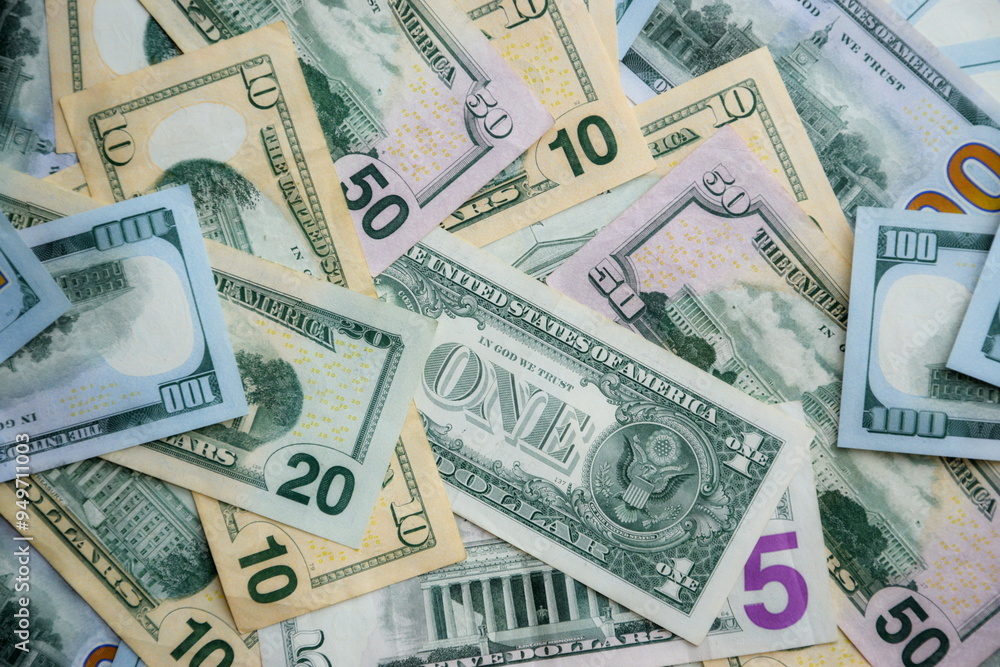 Big amount of US dollar bills in different nominations on table. Many dollar banknotes under natural light Big amount of US dollar bills in different nominations on table. Many dollar banknotes under natural light