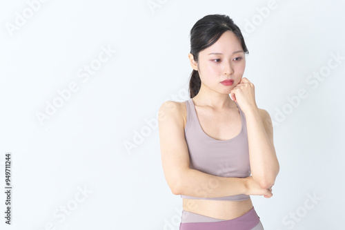 悩んでいるヨガウェアの女性