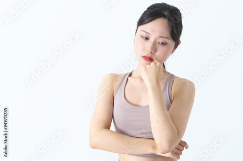悩んでいるヨガウェアの女性