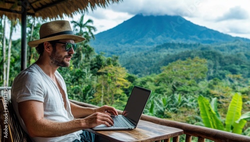 A digital nomad working on their laptop at an outdoor terrace overlooking the jungle, with a charming volcano in the background.