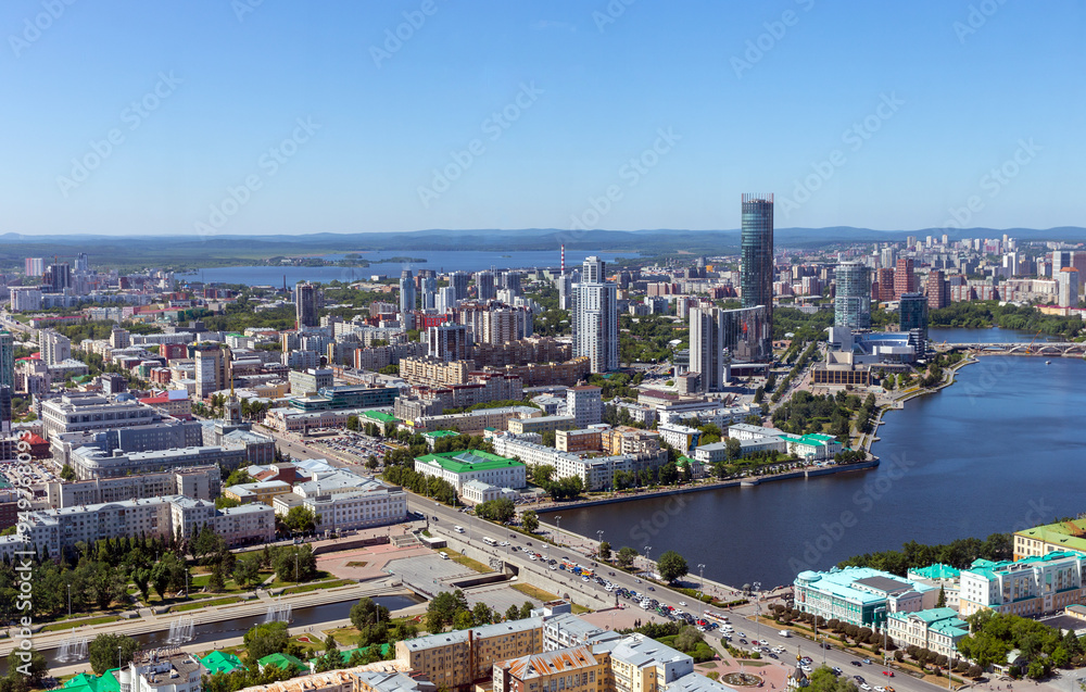 Obraz premium Above view of central part of modern city with skyscrapers and residential buildings. River and bridge on summer day