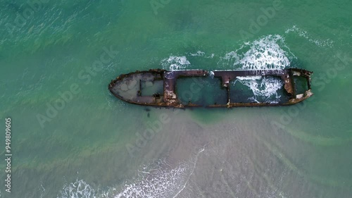 Drone hovering over old rusty shipwreck at the coast in Denmark