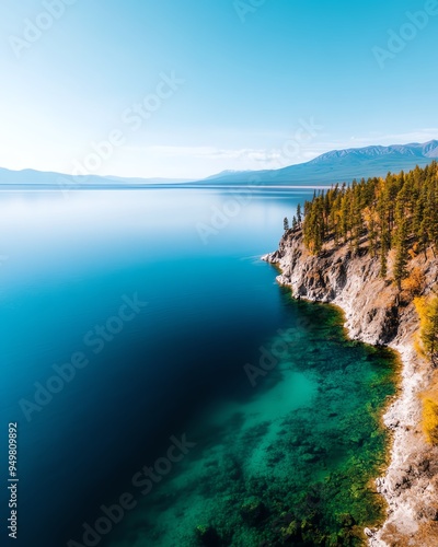 Aerial view of a scenic lake with clear blue water and a rocky shoreline.