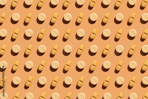 Pattern of different pills on orange background, creating a visually striking geometric layout. Creative pills concept