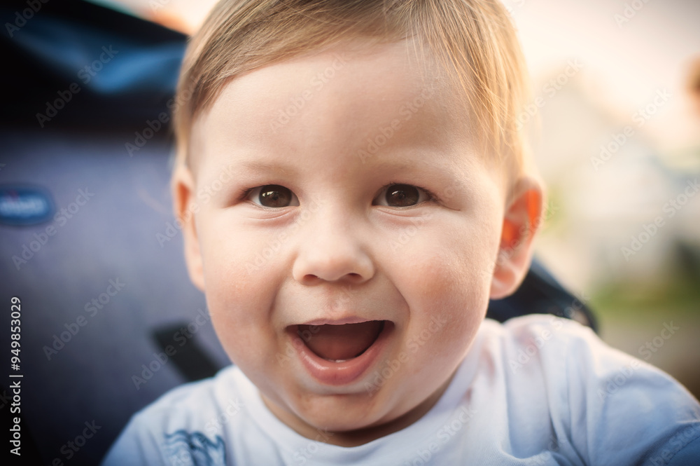A joyful baby boy laughing while sitting outdoors in a sunlit park during a warm afternoon in early spring A joyful baby boy laughing while sitting outdoors in a sunlit park during a warm afternoon in early spring