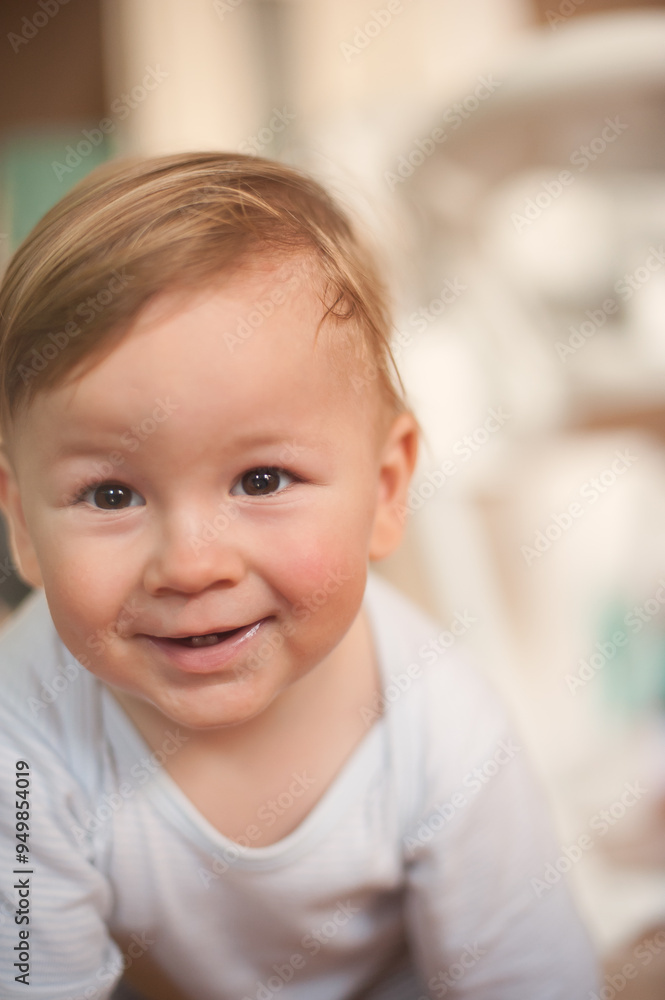 Happy baby with light brown hair smiling warmly in a cozy indoor setting during golden hour Happy baby with light brown hair smiling warmly in a cozy indoor setting during golden hour