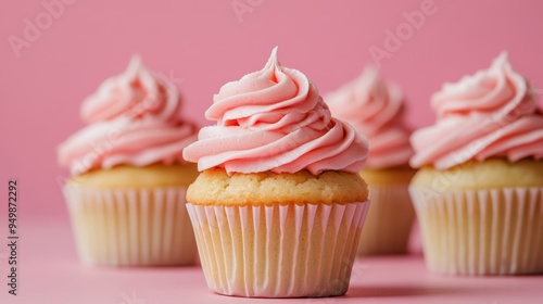 Delectable vanilla cupcakes with pink frosting on pastel background