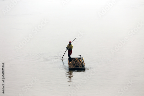 Workers dig sand from a river and load it onto trucks in Cameroon