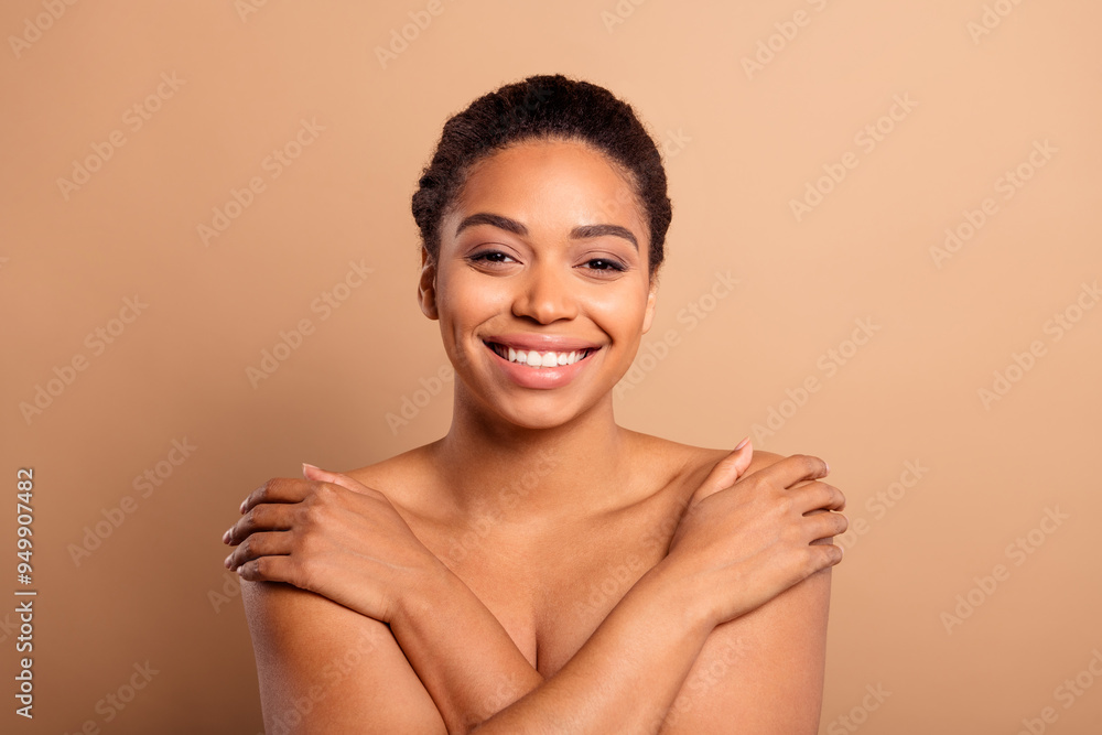 Photo of gorgeous cheerful woman hugging self naked shoulders isolated on beige pastel color background Photo of gorgeous cheerful woman hugging self naked shoulders isolated on beige pastel color background