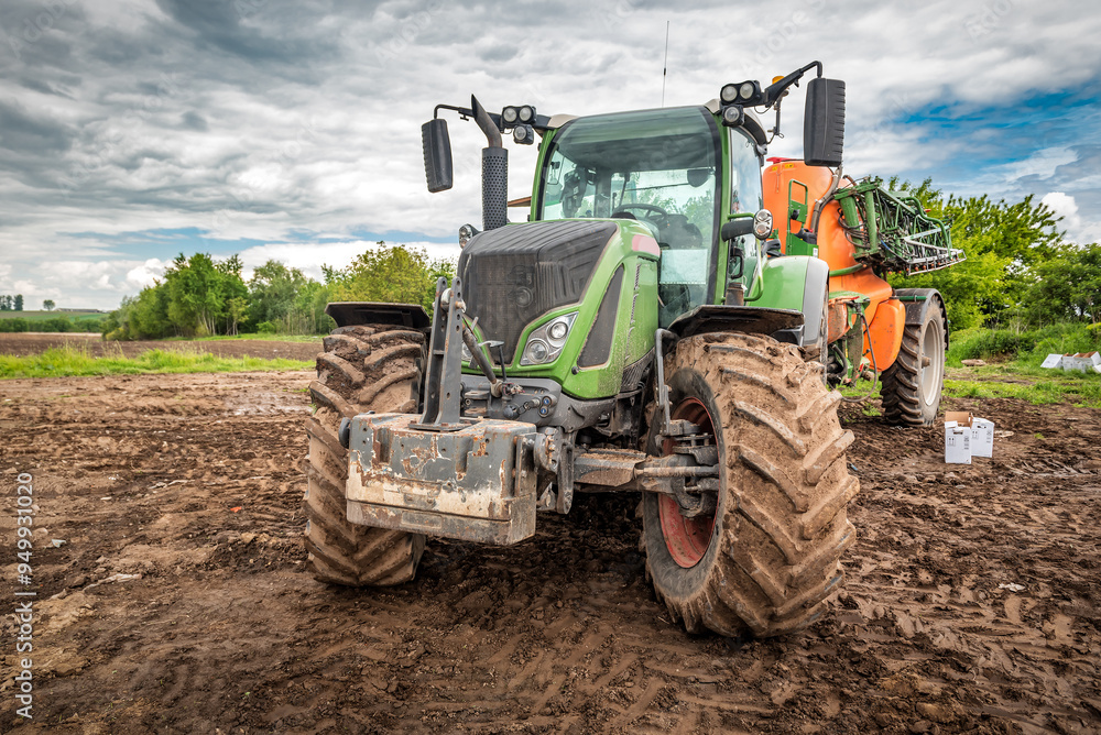 Tractor working on the plowed farm field, agricultural transport, pesticide Tractor working on the plowed farm field, agricultural transport, pesticide