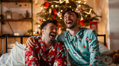 Two boyfriends in matching pajamas burst into laughter on christmas morning in their festive bedroom