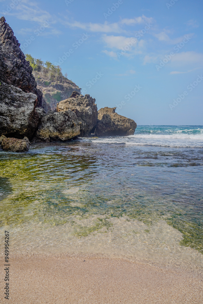 A rocky shoreline with a body of water in front of it A rocky shoreline with a body of water in front of it