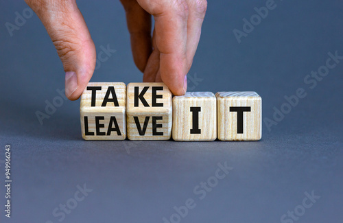 Take or leave it symbol. Businessman turns beautiful wooden cubes and changes words Leave it to Take it. Beautiful grey table grey background. Copy space. Business and take or leave it concept.
