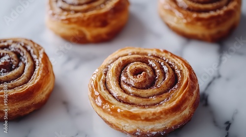 Freshly baked cinnamon rolls, golden brown swirls, flaky pastry texture, caramelized sugar glaze, white marble countertop, food photography, warm tones.