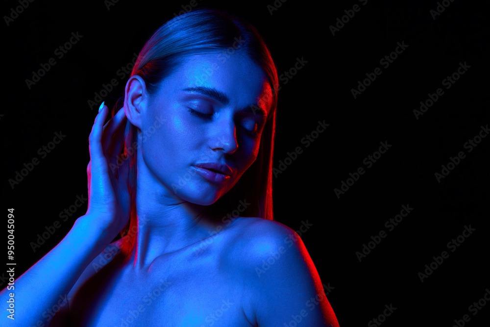 Portrait of beautiful young woman with perfect clear skin and straight hair against black studio background in neon light. Concept of natural beauty, skincare, cosmetics, wellness, spa Portrait of beautiful young woman with perfect clear skin and straight hair against black studio background in neon light. Concept of natural beauty, skincare, cosmetics, wellness, spa