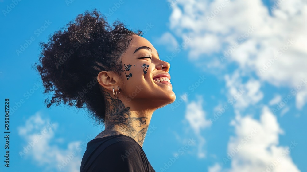 Side profile portrait of a happy woman with face tattoos and piercings, breathing fresh air outdoors under a blue sky, smiling. Side profile portrait of a happy woman with face tattoos and piercings, breathing fresh air outdoors under a blue sky, smiling.
