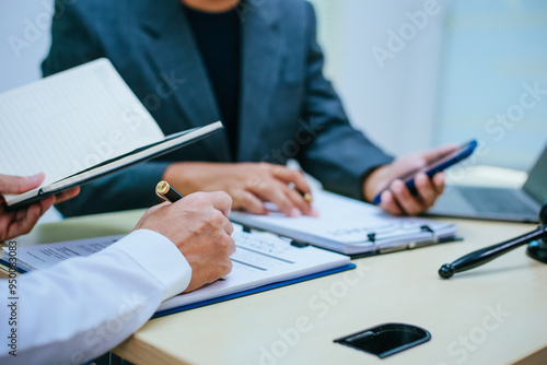 Two lawyers consult in a modern office, presenting compelling arguments and demonstrating their expertise, trying to win a case with their legal acumen and persuasive skills.
 photo