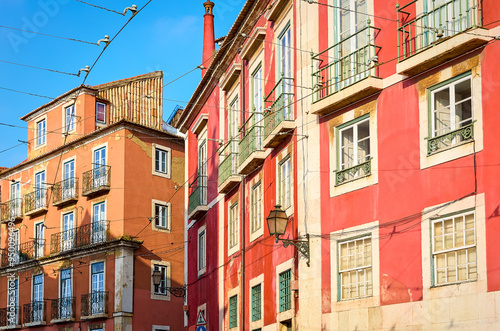 Lisbon, Portugal. Old town narrow street with tramline in Alfama district of old Popular touristic attraction Lisboa city. Public tramways trasport road photo