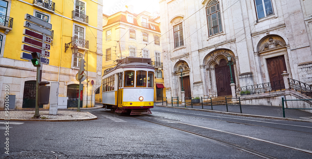Fototapeta premium Lisbon, Portugal. Vintage retro tram on narrow bystreet tramline in Alfama district of old town. Popular touristic attraction Lisboa city. Public tramways trasport
