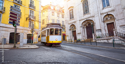 Lisbon, Portugal. Vintage retro tram on narrow bystreet tramline in Alfama district of old town. Popular touristic attraction Lisboa city. Public tramways trasport