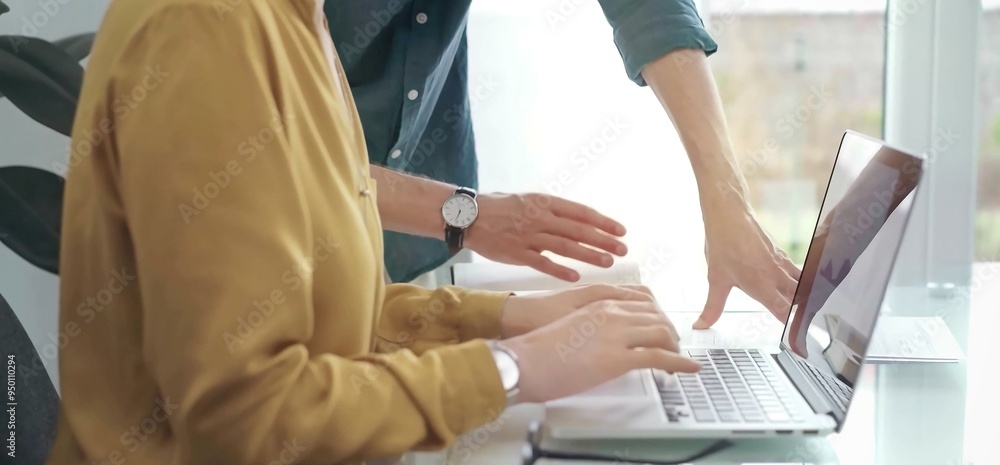 Team collaboration over financial reports. Close-up view of two business people, professionals analyzing financial charts and data on a desk near a laptop computer Team collaboration over financial reports. Close-up view of two business people, professionals analyzing financial charts and data on a desk near a laptop computer