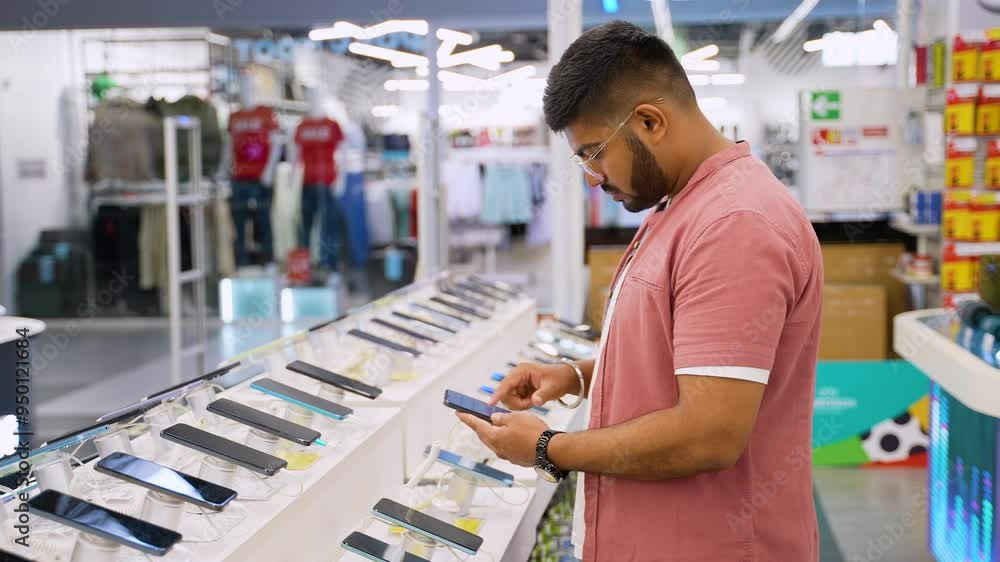 Indian man buying a new smartphone with discount in a tech store Indian man buying a new smartphone with discount in a tech store