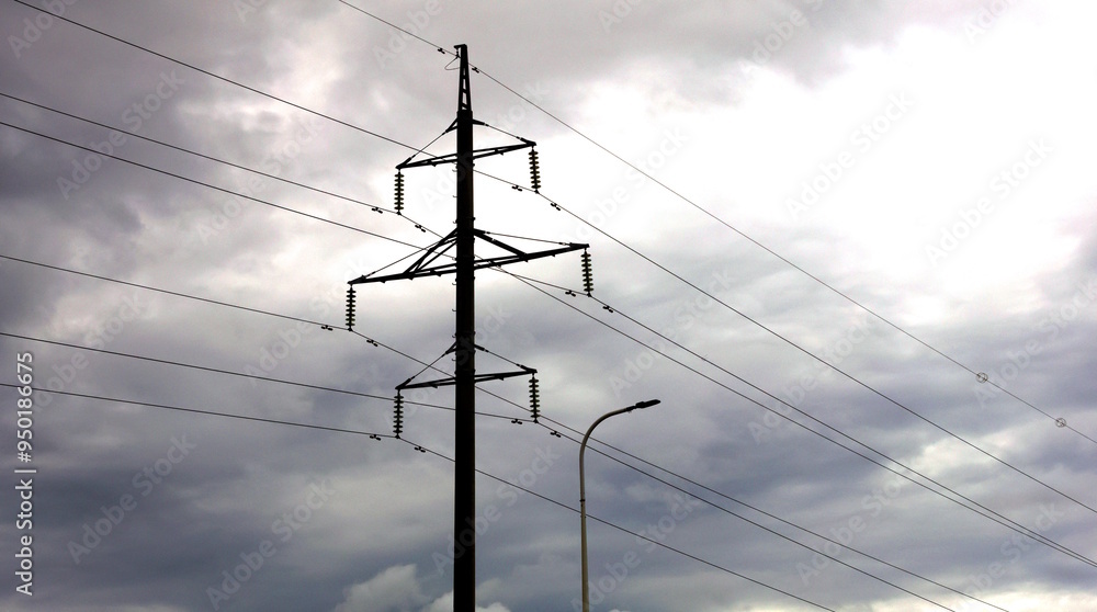 An electric pole with strings of wires stretched out against a picturesque sky at dusk An electric pole with strings of wires stretched out against a picturesque sky at dusk