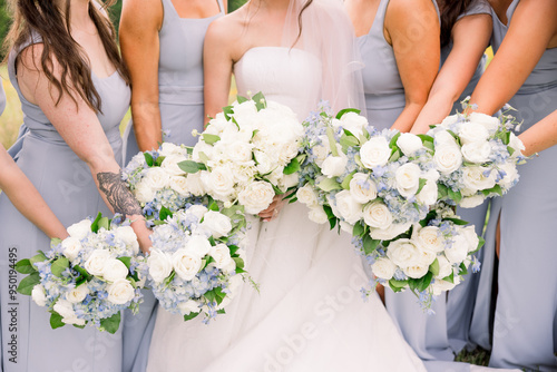 bride and bridesmaids holding classic white floral bouquets.