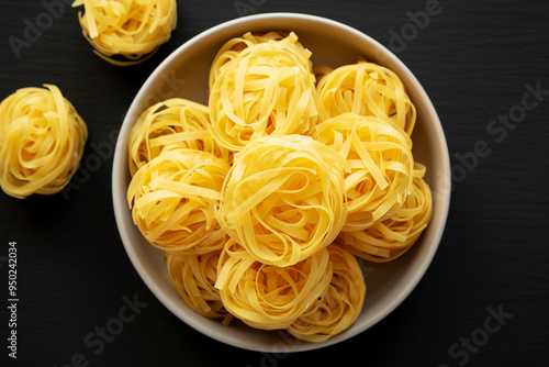 Raw Dry Tagliatelle Pasta in a Bowl, top view. Flat lay, overhead, from above.