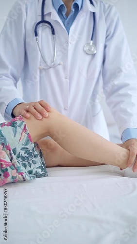 Doctor and kid patient. Orthopedist examining girl's knee in medical clinic. Medicine and health care photo