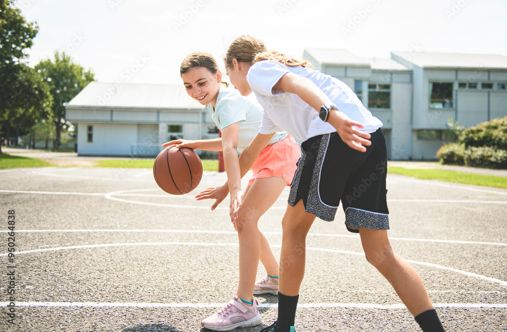 Fototapeta premium two childs girls in sportswear playing basketball game