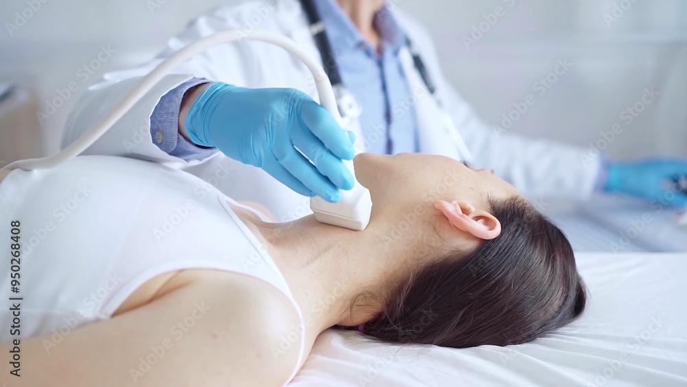 Doctor man wearing blue medical gloves is using ultrasound equipment on neck of female patient lying down for a medical examination Doctor man wearing blue medical gloves is using ultrasound equipment on neck of female patient lying down for a medical examination